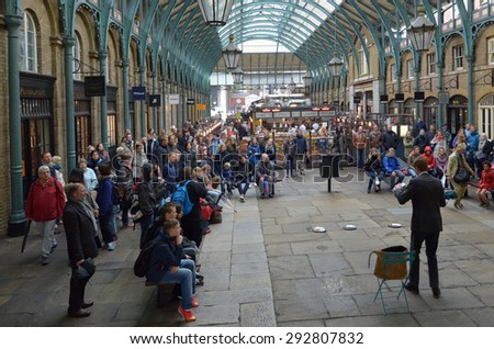 LONDON - MAY 15 2015:Spectators watching street show in Covent Garden in London, UK. Covent Garden is the only district in London to have a license for street performers and entertainers.