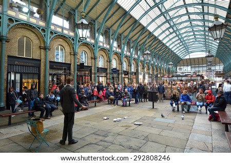 LONDON - MAY 15 2015:Spectators watching street show in Covent Garden in London, UK. Covent Garden is the only district in London to have a license for street performers and entertainers.