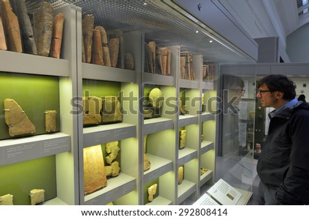 LONDON - MAY 15 2015:Visitor in the British Museum look at cuneiform tablets.Almost 2M cuneiform tablets have been excavated of which only approximately less then 100,000 have been read or published.