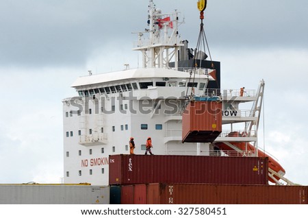 AUCKLAND,  NZL -OCT 13 2015:Cargo ship workers unloading containers in Ports of Auckland New Zealand.ItÃ¢??s New Zealand\'s busiest port and the third largest container terminal in Australasia.