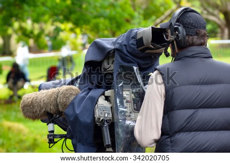 AUCKLAND,  NZL - NOV 22 2015: Camera operator shooting on location event. In 2006, there were approximately 27,000 television, video, and motion picture camera operators employed in the United States.