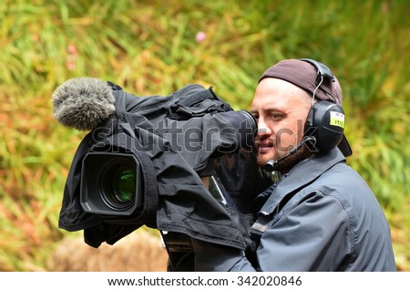 AUCKLAND,  NZL - NOV 22 2015: Camera operator shooting on location event. In 2006, there were approximately 27,000 television, video, and motion picture camera operators employed in the United States.