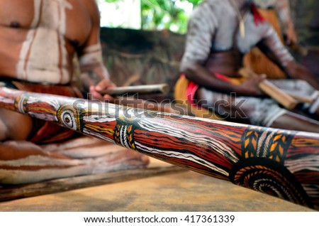 Yirrganydji Aboriginal men play Aboriginal music on didgeridoo and wooden instrument during Aboriginal culture show in Queensland, Australia.