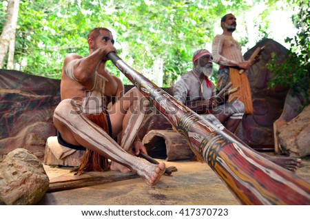 Yirrganydji Aboriginal men play Aboriginal music on didgeridoo and wooden instrument during Aboriginal culture show in Queensland, Australia.