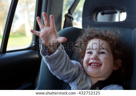 Happy  little  child (girl age 2) travel in a car sit during family holiday vacation.