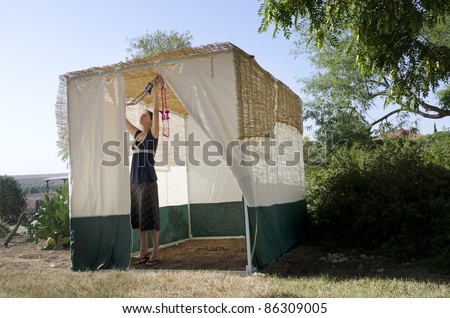 Jewish woman decorating here family Sukkah for the Jewish festival of Sukkot. A Sukkah is a temporary structure where meals are taken for the week.