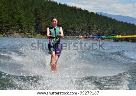 A water skier woman water skiing on a lake.