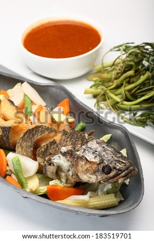 Fried fish and boiled water spinach served on a dish