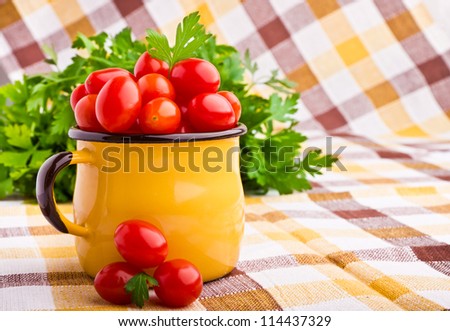 Yellow mug full of fresh cherry tomatoes