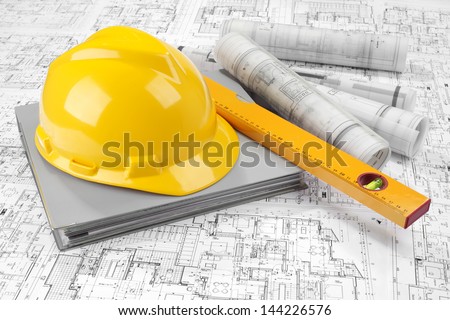 Yellow helmet, level, grey folder document and project drawings
