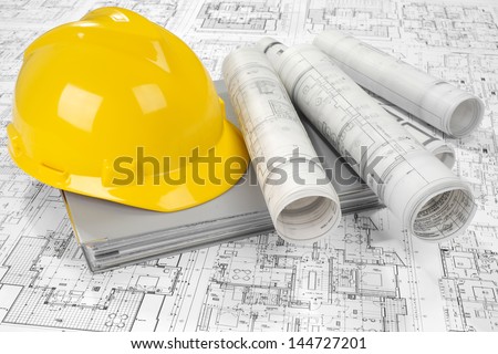 Yellow helmet, grey folder document and project drawings