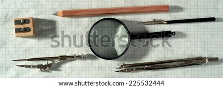 drawing tools and magnifying glass on graph paper