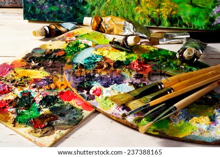 palette with paintbrushes and canvas  paintings