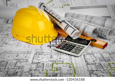 Yellow helmet, calculator, level and project drawings