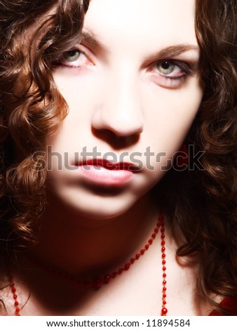 A portrait about an attractive woman with white skin and long brown wavy hair whose look is glamorous