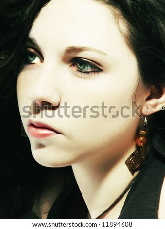A portrait about an attractive lady with white skin and long brown wavy hair who looks far away and desires something