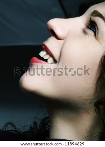 A portrait about a pretty lady with white skin and long brown wavy hair, she is looking up and she is laughing