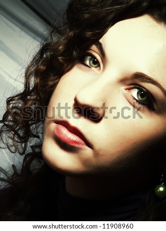 A portrait about a pretty lady with white skin, long brown wavy hair, green eyes and whose look is glamorous