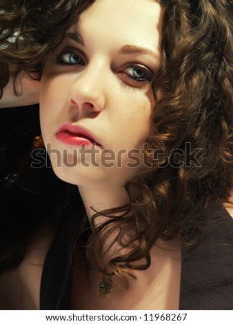 A portrait about a pretty lady with white skin and long brown wavy hair who wears a nice dark dress and she is thinking