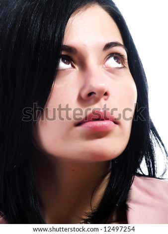 A closeup portrait about an elegant trendy woman with black hair who is looking up and she is dreaming something. She is wearing a pink stylish coat.