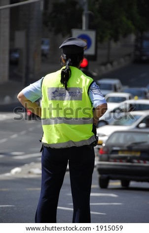 Israeli Police woman stands watch over the mid day traffic in downtown Jerusalem