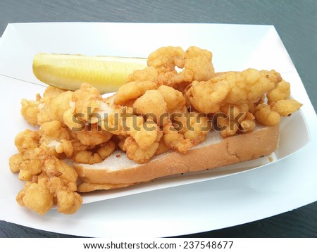 Deep-fried clam strips on a bun with a pickle