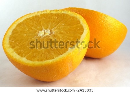 Fresh orange cut in half, on white.