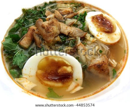 Asian noodle soup with boiled eggs, vermicelli, chicken, kale and fried onions