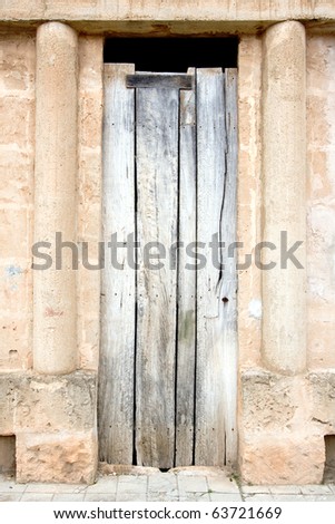 Closed simple wooden front door without handle between sandstone columns - detail of building