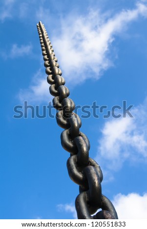 Metal chain goes up into the sky with clouds