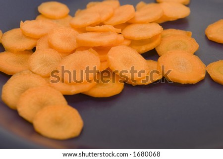 Carrots cut by circles on a dark blue plate