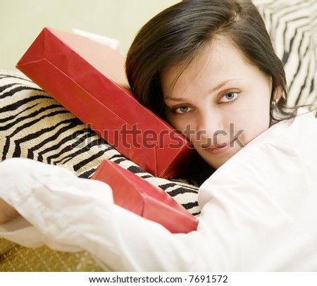 Girl lie on the sofa with a heap of gifts