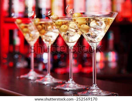 Four Martini cocktails on a bar counter