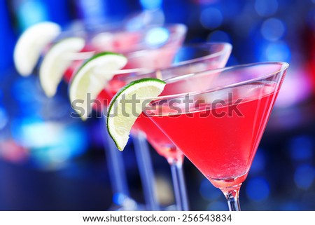 Four cosmopolitan cocktails on a bar counter