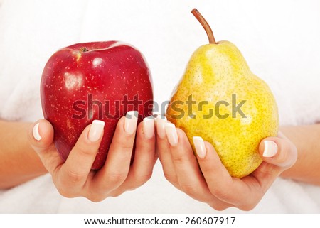 Young woman holding apple and pear in her hands, isolated on white