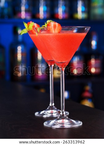 Two Strawberry Daiquiri cocktails on a bar counter in a night club
