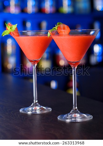 Two Strawberry Daiquiri cocktails on a bar counter in a night club