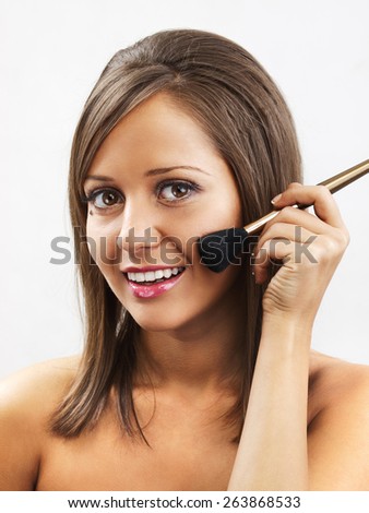 Close up of young woman face, holding all types of brushed in one hand