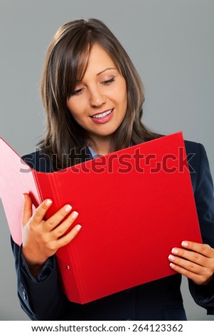 Businesswoman holding folders isolated on gray background smiling