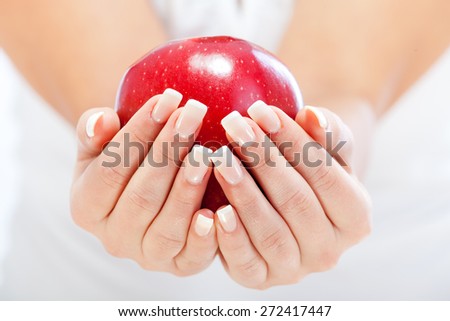 Young woman holding red apple in her hands, isolated on white