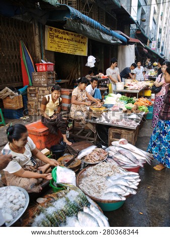 Yangon, Myanmar - February 24, 2011 : Young Burmese woman selling fresh seafood in the street market.