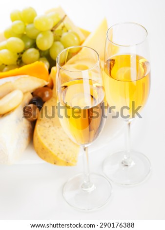 Different types of cheese, white grapes and white wine