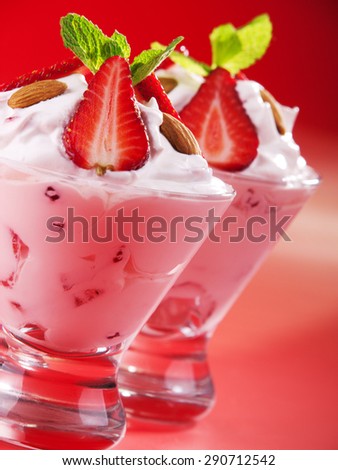 Strawberry cream in two glasses garnished with strawberries, almonds and fresh mint