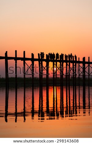 U Bein Bridge at sunset with people crossing Ayeyarwady River, Mandalay, Myanmar