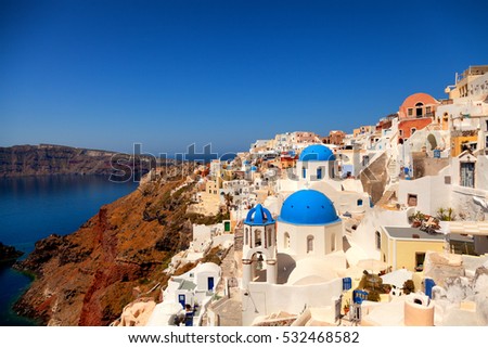 Landscape of Oia town in Santorini, Greece with blue dome churches on foreground. Vertical shot
