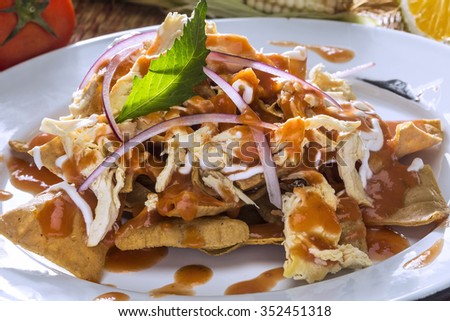 Fried Tortillas in red sauce with chicken