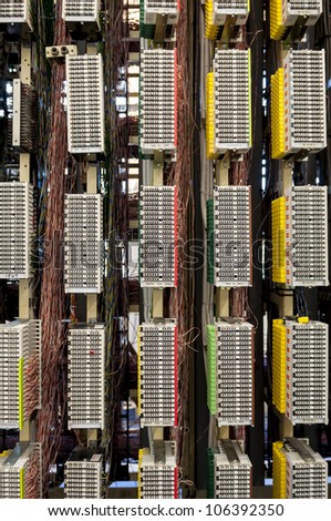 A telephone network switchboard showing the various colours of cables.