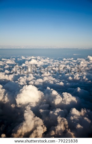 A photograph takem from above the clouds showing a variety of different cloud formations.
