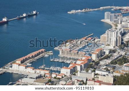 An elevated point of view of the bay of Gibraltar showing various architecture and a marina.