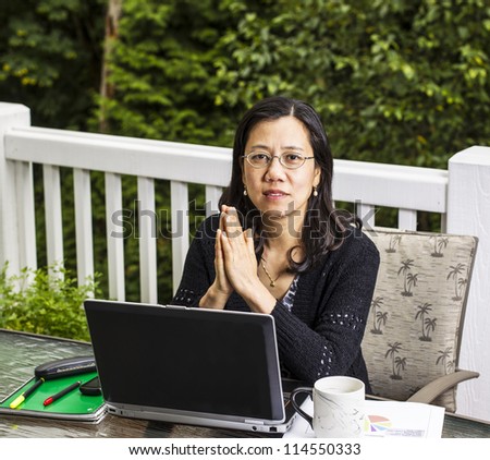 Mature women on outdoor deck thinking while working at home office